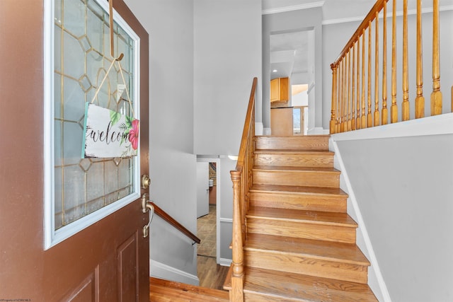 staircase featuring crown molding and hardwood / wood-style floors