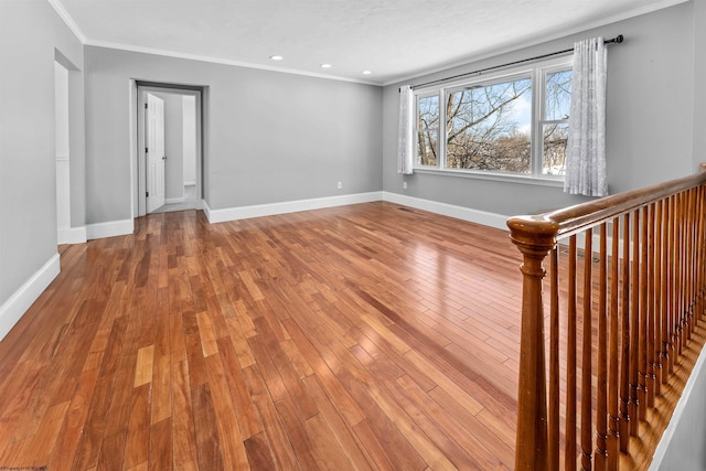 empty room with crown molding and wood-type flooring