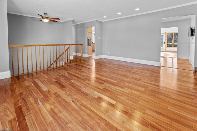 empty room with ornamental molding and light hardwood / wood-style floors