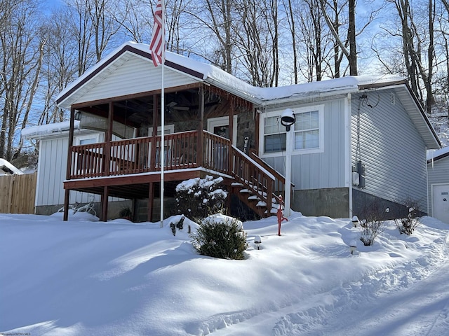 chalet / cabin with a garage, a ceiling fan, and stairs