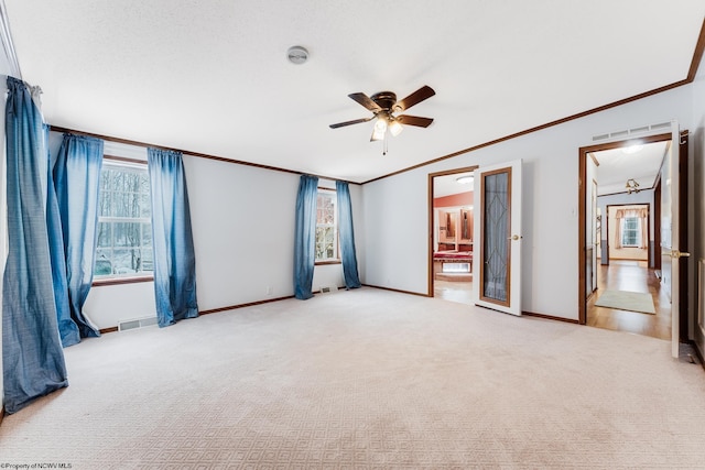 empty room featuring ornamental molding, light carpet, and ceiling fan