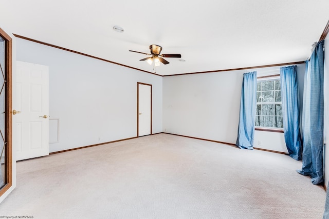 spare room with ornamental molding, light colored carpet, and ceiling fan