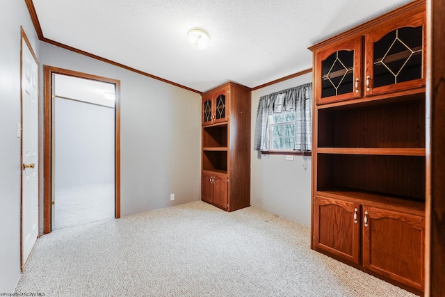 spare room with crown molding and light colored carpet