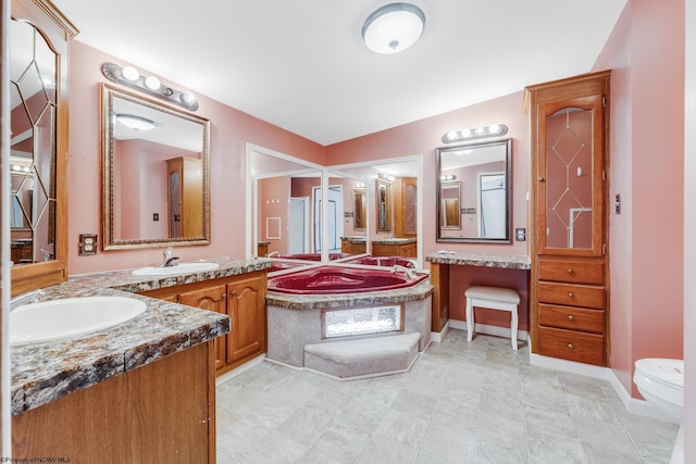 bathroom with vanity, toilet, and a tub