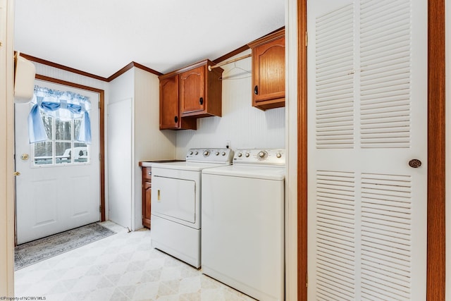 laundry area with cabinets, crown molding, and washing machine and clothes dryer