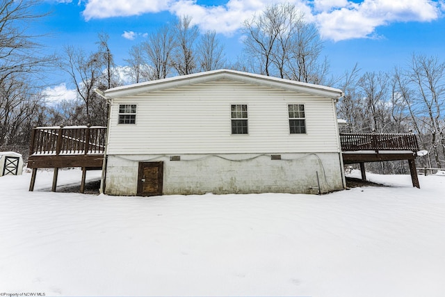 view of snow covered exterior featuring a wooden deck