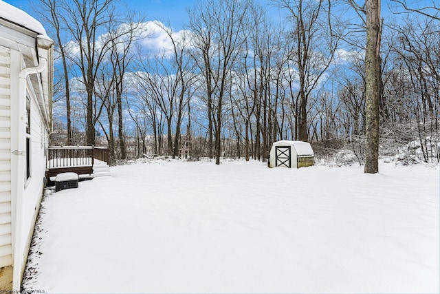 snowy yard featuring an outdoor structure