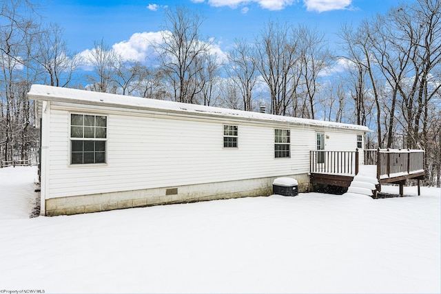 snow covered property featuring a wooden deck