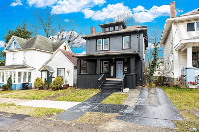 view of front of house featuring covered porch and a front yard