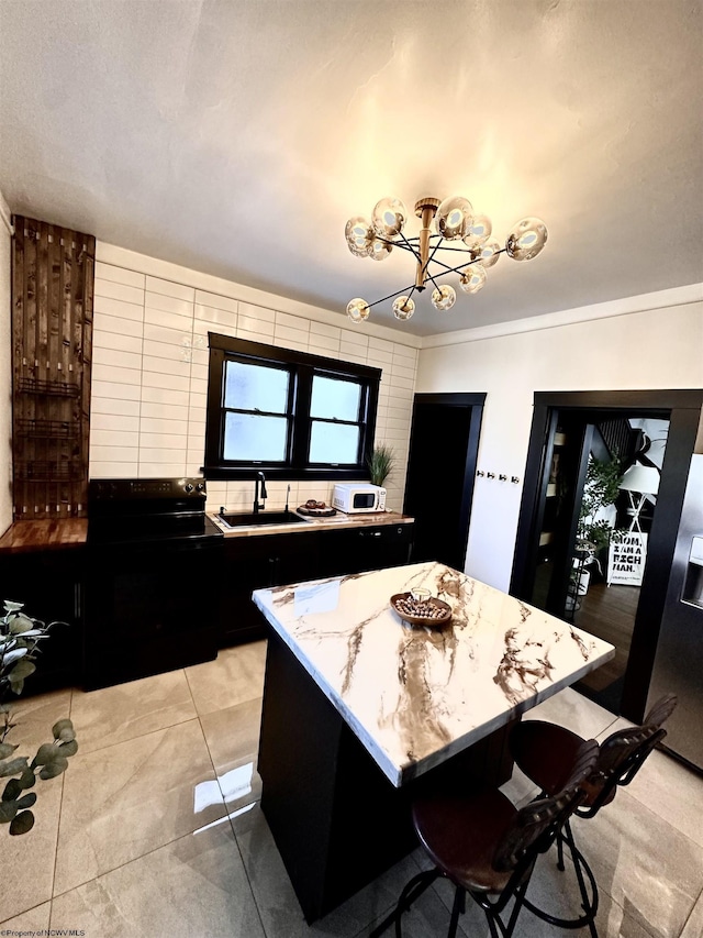 kitchen featuring light stone counters, sink, a kitchen breakfast bar, and a kitchen island