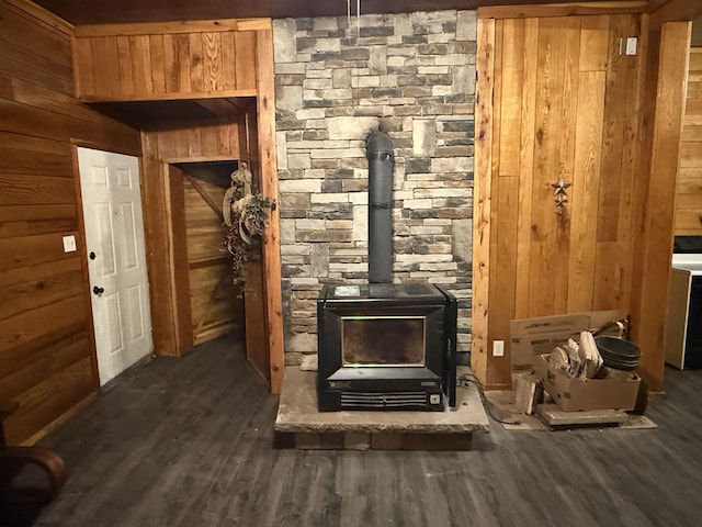 interior details featuring wood-type flooring, a wood stove, and wood walls