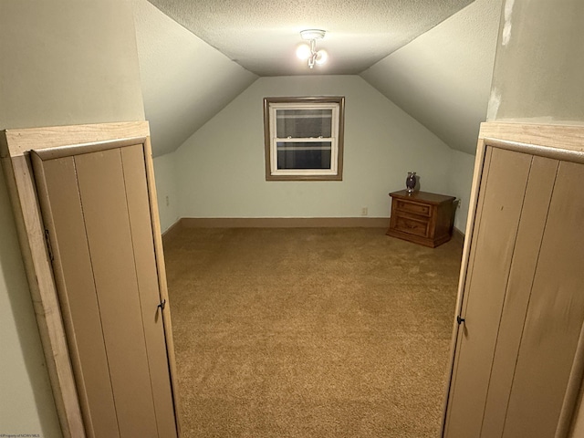 bonus room featuring light colored carpet, vaulted ceiling, and a textured ceiling