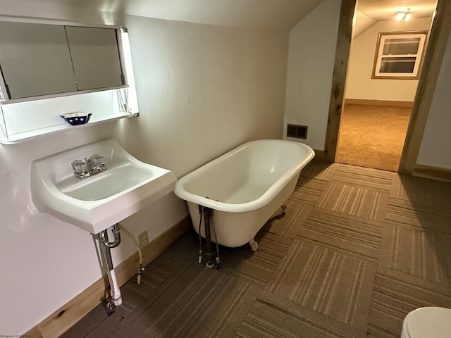 bathroom featuring toilet and a tub to relax in