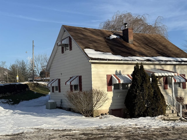 view of snowy exterior featuring central air condition unit