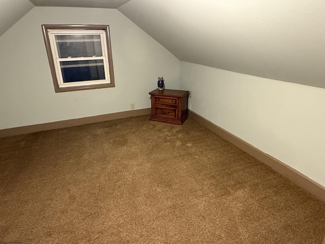 additional living space with carpet floors and vaulted ceiling