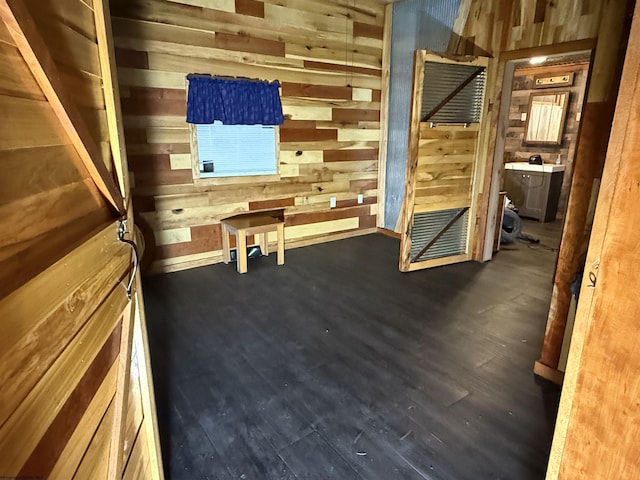 interior space with dark hardwood / wood-style floors and wooden walls