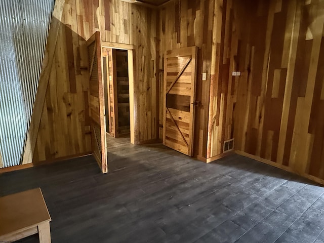 misc room featuring dark hardwood / wood-style flooring and wood walls