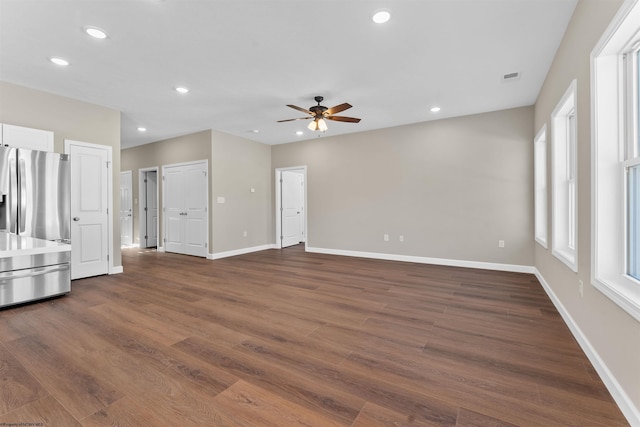 unfurnished living room featuring dark wood-type flooring and ceiling fan