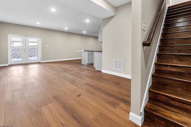 unfurnished living room with light wood-type flooring and french doors