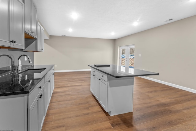 kitchen with light hardwood / wood-style floors, a center island, and sink