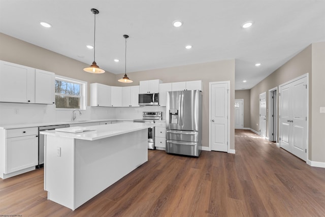 kitchen featuring pendant lighting, white cabinetry, stainless steel appliances, and a kitchen island