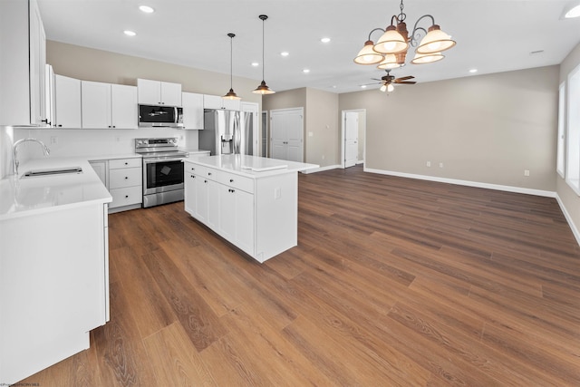 kitchen featuring white cabinetry, stainless steel appliances, a center island, and sink