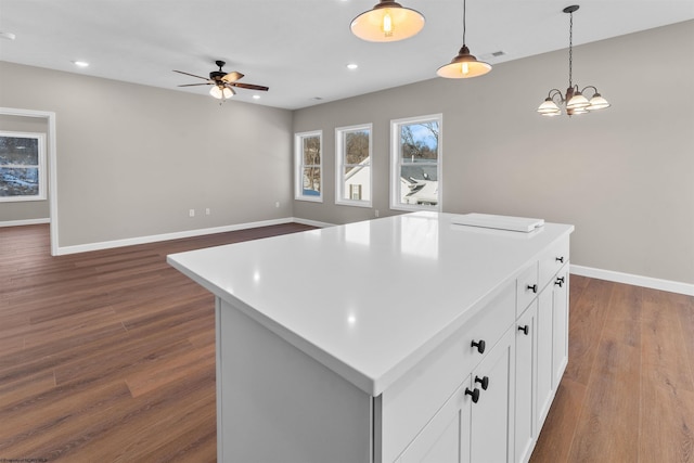 kitchen with white cabinetry, hanging light fixtures, dark hardwood / wood-style flooring, and a kitchen island