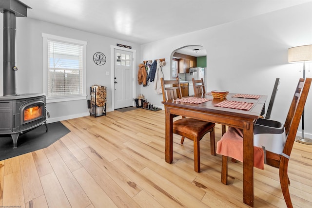 dining area with light wood-type flooring and a wood stove