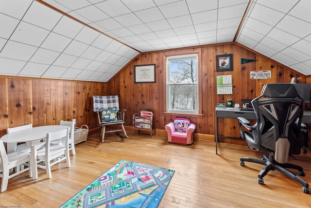 office area with hardwood / wood-style flooring, lofted ceiling, and wood walls