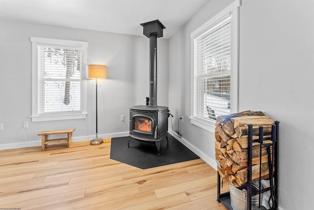 sitting room featuring hardwood / wood-style floors and a wood stove