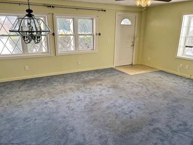 carpeted entrance foyer featuring a healthy amount of sunlight and ceiling fan