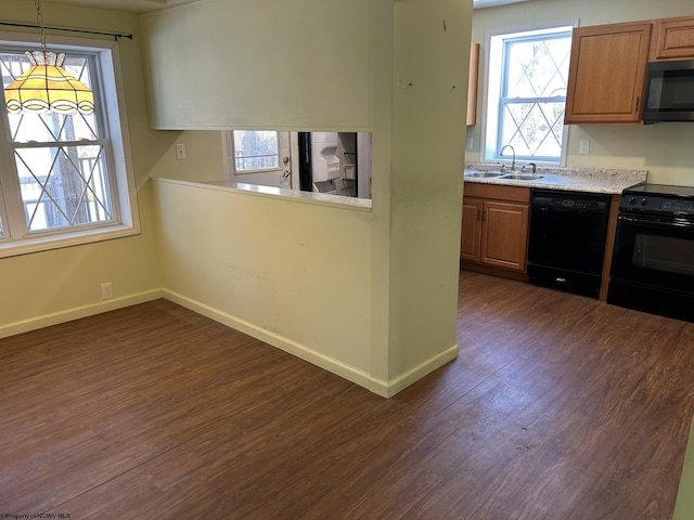 kitchen featuring dark hardwood / wood-style flooring, sink, black appliances, and hanging light fixtures