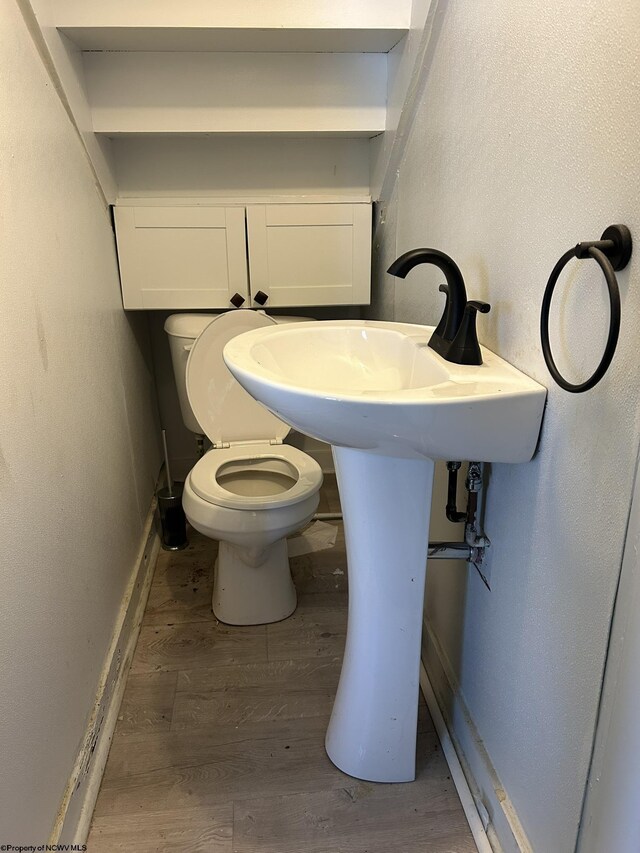 bathroom with wood-type flooring and toilet