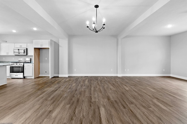 unfurnished living room featuring an inviting chandelier and dark hardwood / wood-style floors