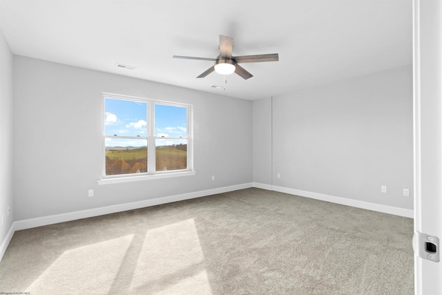 unfurnished room with ceiling fan and carpet