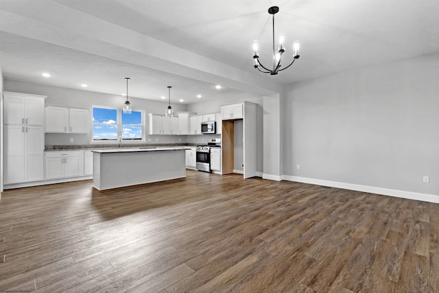 kitchen with dark wood-type flooring, appliances with stainless steel finishes, white cabinetry, a center island, and decorative light fixtures