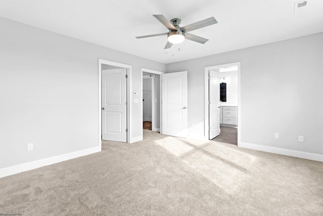 unfurnished bedroom with ceiling fan, connected bathroom, and light colored carpet