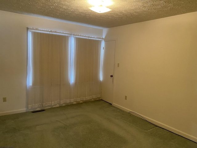 empty room with carpet floors and a textured ceiling