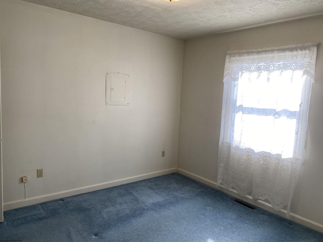 empty room with carpet floors and a textured ceiling