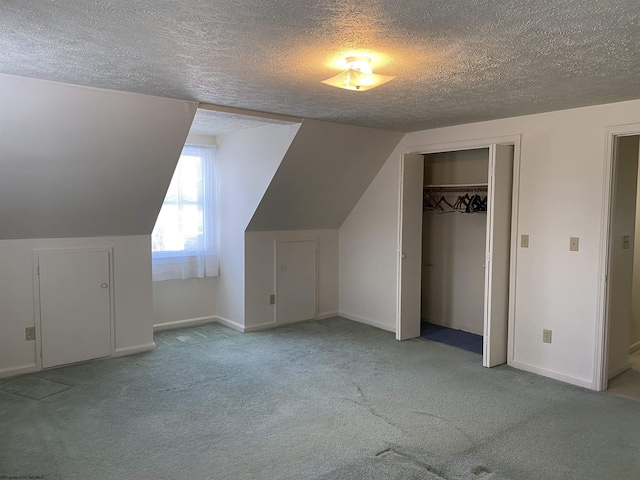 additional living space featuring vaulted ceiling, light carpet, and a textured ceiling