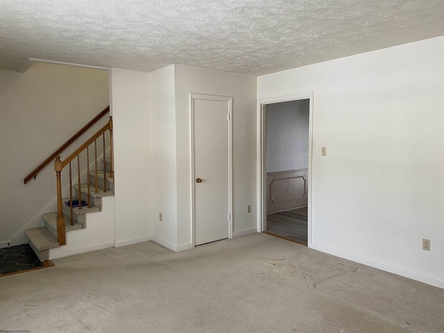 carpeted spare room featuring a textured ceiling