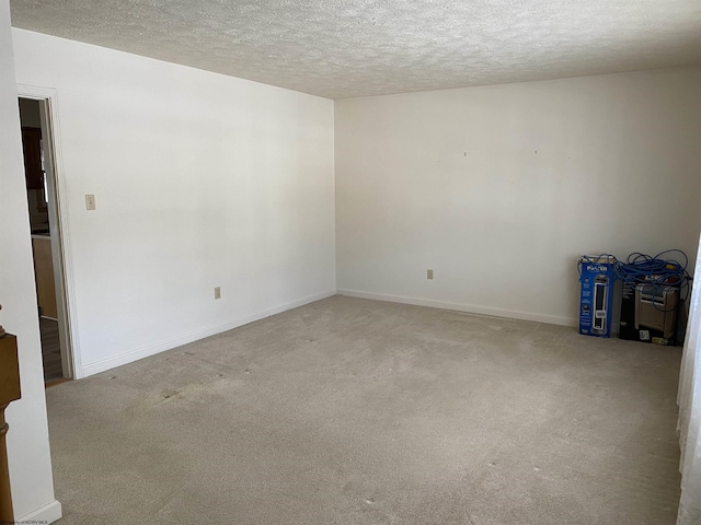 spare room with light carpet and a textured ceiling