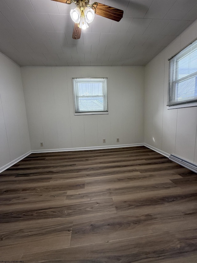 unfurnished room featuring dark hardwood / wood-style floors, ceiling fan, and baseboard heating