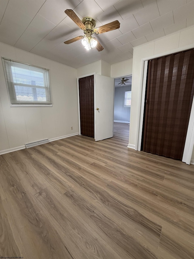 unfurnished bedroom featuring hardwood / wood-style flooring and ceiling fan