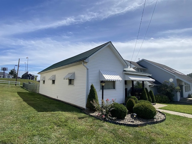 view of side of home with a yard