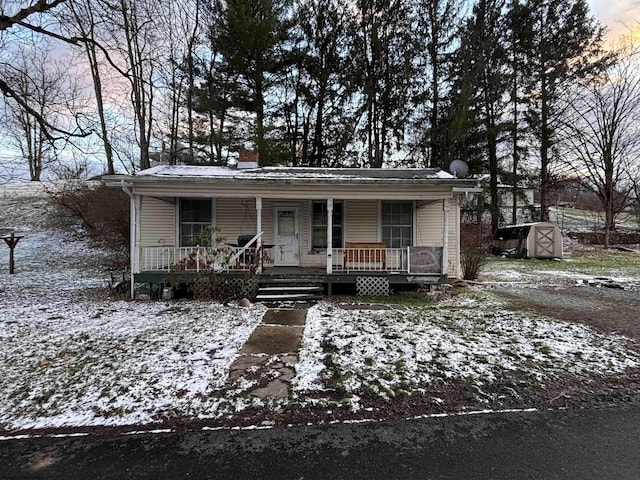 view of front of property with covered porch and a storage unit