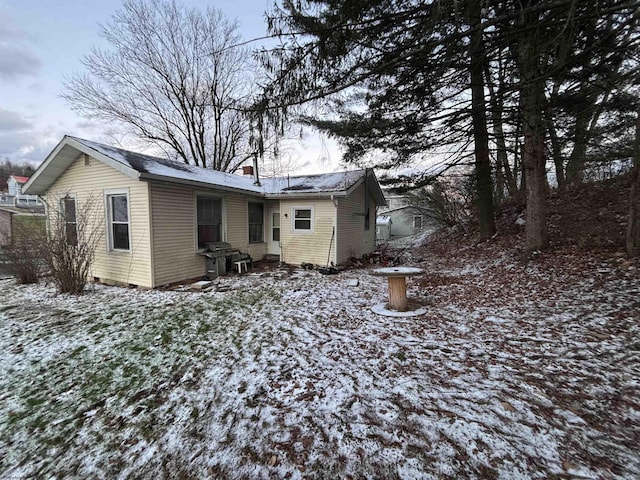 view of snow covered back of property