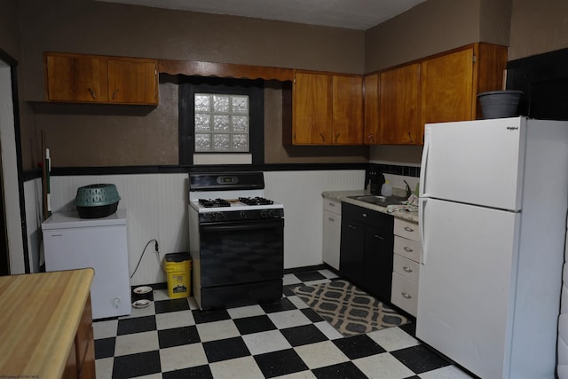 kitchen featuring refrigerator, range with gas stovetop, sink, and white fridge