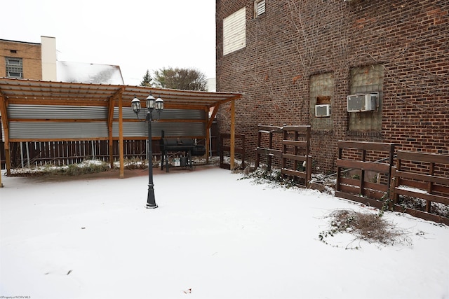 yard layered in snow with an AC wall unit