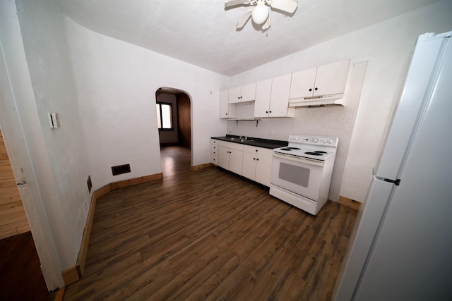 kitchen with refrigerator, white electric stove, tasteful backsplash, white cabinets, and dark wood-type flooring